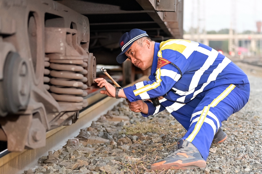 哈爾濱車輛段哈南下行運用車間五場二班四組檢車員正在對車輛走行部進行檢修作業(yè)。