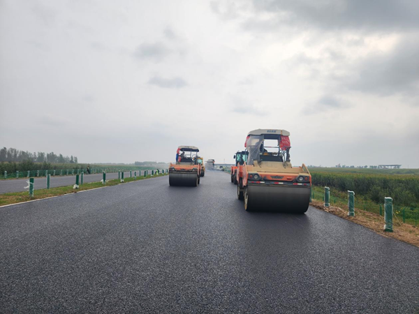 攤鋪機(jī)、壓路機(jī)進(jìn)行協(xié)同作業(yè)。圖片由中國鐵建大橋局四公司提供