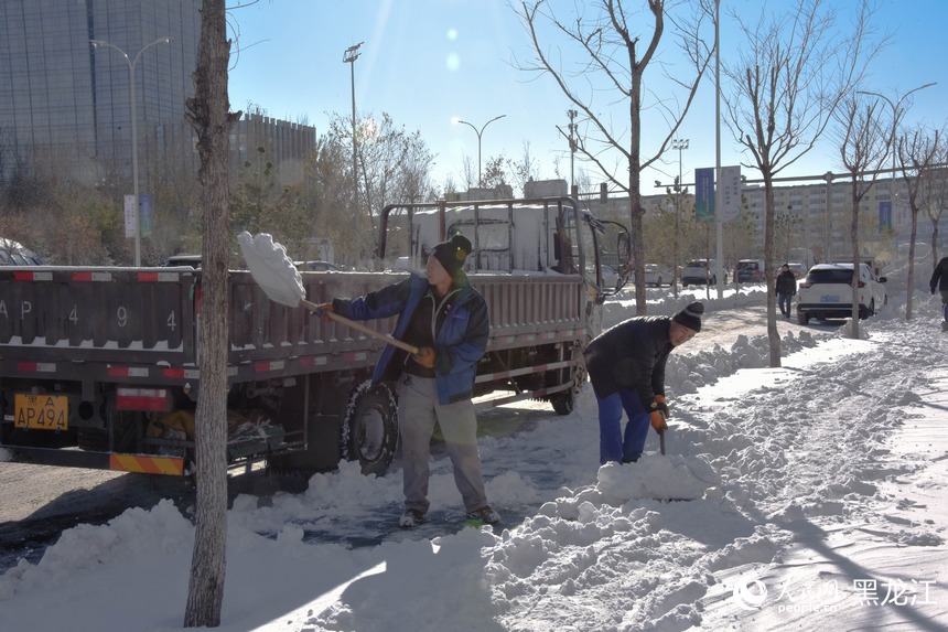 工人正在將雪裝車。人民網(wǎng) 徐成龍攝