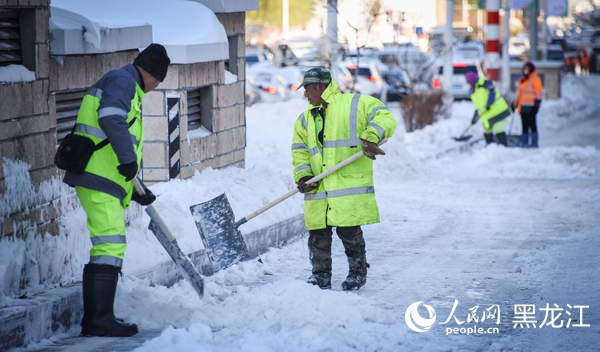 哈爾濱市區(qū)內(nèi)環(huán)衛(wèi)工人正在清雪。人民網(wǎng)記者 蘇靖剛攝