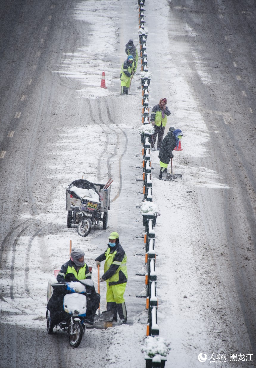 環(huán)衛(wèi)工人正在清理道路積雪，保障路面暢通。人民網記者 蘇靖剛攝