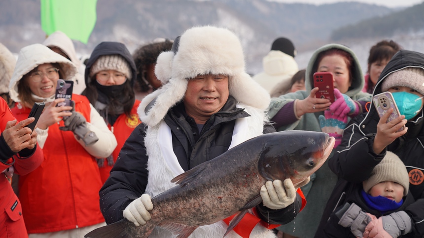 黑龍江海林蓮花湖第二屆冷水魚冬捕節(jié)漁民懷抱第一網魚。